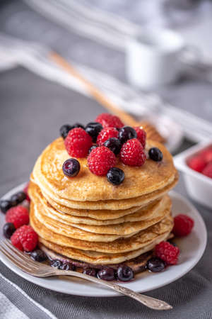 Homemade pancakes with raspberries and blueberries on grey napkin.の写真素材