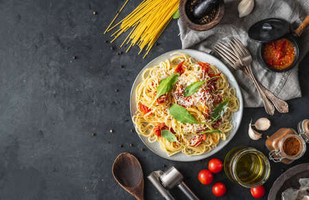 Italian dinner with pasta on ceramic plate with ingredients around on black background. Flat view. Top view.の写真素材