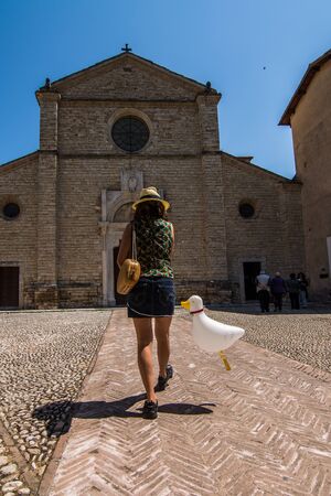 Farfa, Italy - May 31, 2015: the facade of the abbey church of Farfa. While some tourists are in line to enter to visit the church, a woman walking with a balloon in handのeditorial素材