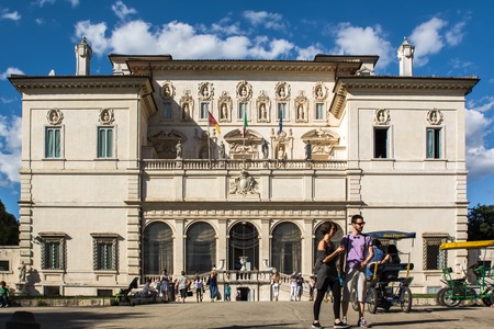 Rome, Italy - June 21, 2014: the entrance of the Galleria Borghese in Villa Borghese where citizens and tourists strolling in the park on a sunny Sunday afternoon. Some tourists use the rishock to stroll along the avenues of the villa.のeditorial素材