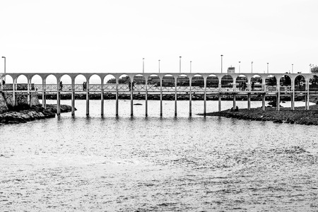 Civitavecchia, Italy - March 29, 2015: at sunset, some people walking on the old dock of the seafront in Civitavecchia.のeditorial素材