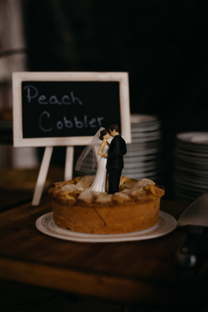 Peach cobbler with bride and groom figures on topの写真素材