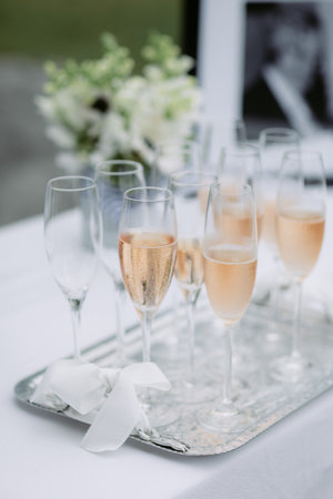 Pink champagne in flutes on a silver tray at a weddingの写真素材