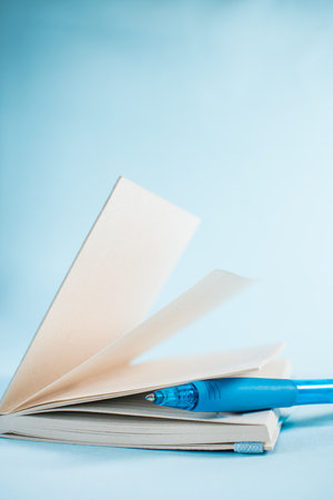 Blue pen in a notebook on blue backgroundの写真素材