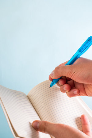 Hand writting on notebook with blue penの写真素材