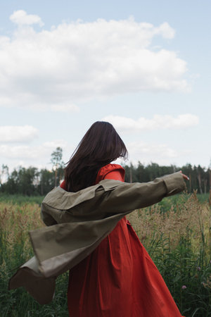 Girl in a red dress in a fieldの写真素材
