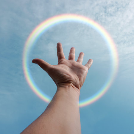 hand up in the air playing with the sunlight, blue backgroundの写真素材