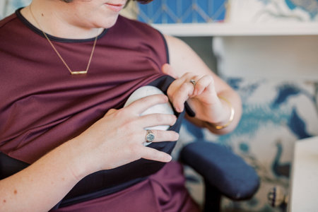 Mom places hands-free pump inside her maroon pumping dress.の写真素材