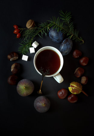 Black tea in a Christmas tree wreath, figs, chestnutsの写真素材