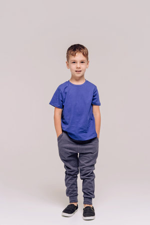 Half-length emotional portrait of caucasian teen boy wearing blue t-shirt. Surprised teenager looking at camera. Handsome happy child, isolated on white background.の写真素材