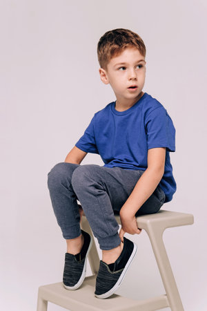 Half-length emotional portrait of caucasian teen boy wearing blue t-shirt. Surprised teenager looking at camera. Handsome happy child, isolated on white background.の写真素材