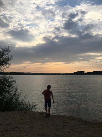 A boy on a lake at sunset.の写真素材