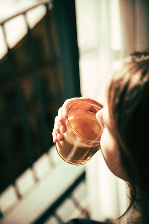 Brunette girl having a coffee for breakfast next to the terraceの写真素材