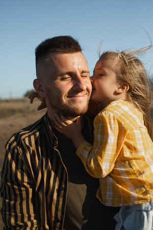Daughter hugging and kissing dadの写真素材