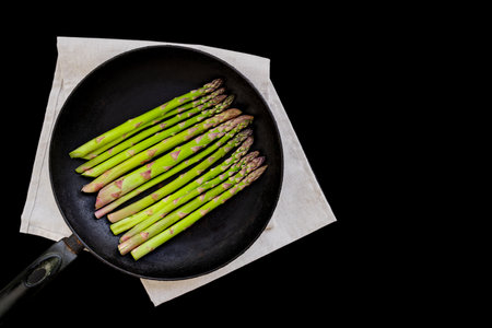 raw asparagus in a pan  black background  copy spaceの写真素材