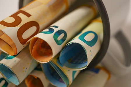 rolled euro banknotes stuffed into a white cupの写真素材