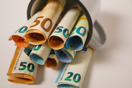 rolled euro banknotes stuffed into a white cupの写真素材