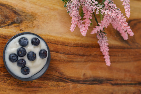 blueberries with yogurt on a black plateの写真素材