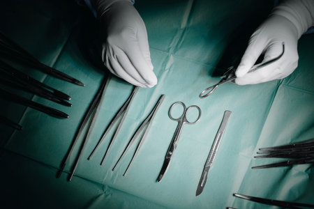 The doctor's hand takes a surgical instrument from the tableの写真素材