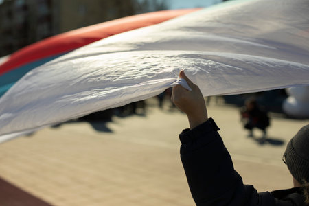Hand holds flag of Russia. Hand holds on to fabric floating in air.の写真素材