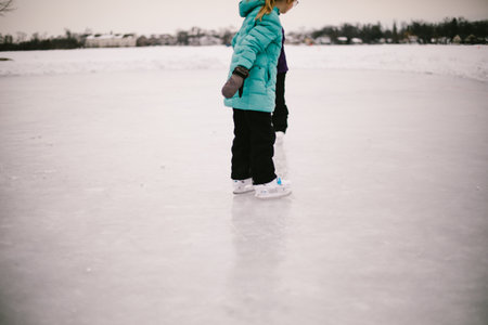 Girl ice skates on frozen pond in winter wonderlandの写真素材
