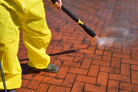 a woman cleans the terrace with a high-pressure cleanerの写真素材