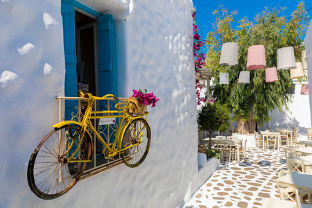 A yellow bicycle hange on stucco building on Naxos Island, Greeceのeditorial素材