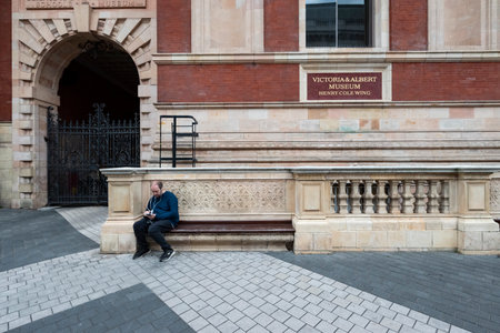 Man using smart phone in front of Vic and Albert Museumのeditorial素材