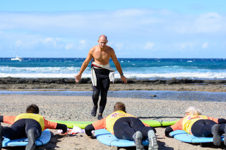 Young woman trying to ride her surf lessons in Las Americas, Tenerifeのeditorial素材