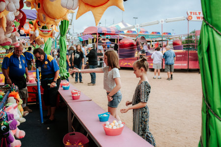 Girls playing a carnival game at local fairのeditorial素材