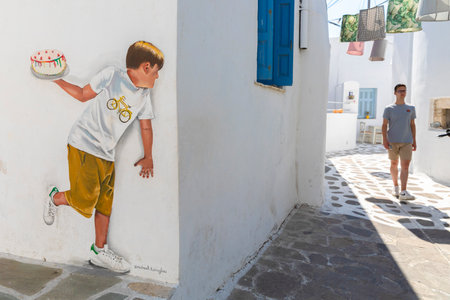 humorous street art between stucco building on Naxos, Greeceのeditorial素材
