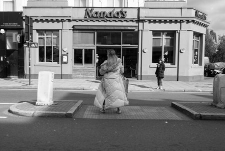 Woman crossing the streets in Cricklewoodのeditorial素材