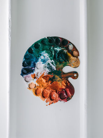 A colorful artist's palette with paints, showcasing an array of vibrant colors in a creative setting.の素材