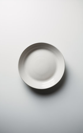 Minimalistic white ceramic plate on a soft gradient background.の素材