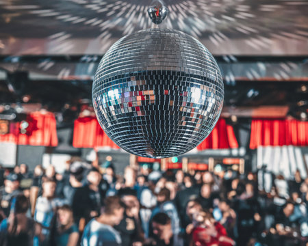 A dazzling disco ball hangs overhead, reflecting vibrant lights in a lively party atmosphere.の素材