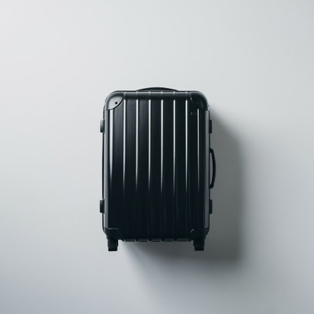 Sleek black suitcase on a light background, showcasing modern travel design.の素材