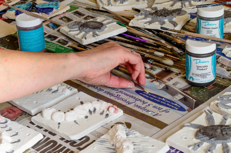 WREXHAM, UNITED KINGDOM - MARCH 14, 2016: Ceramic 'mini beasts' tiles during the glazing process. Part of a workshop project.のeditorial素材