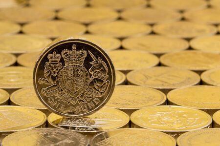 British money, pound coin showing heraldic lion, unicorn, shield and crown on a background of pound coins.の写真素材