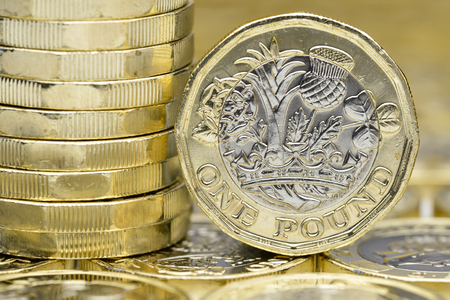 New one pound coins. A stack on a background of coins and one coin showing the back or tails side of the coin. Close up macro detail,の写真素材