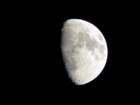 Moon in part shadow in the black night sky showing details of the lunar surface. Copy space.の写真素材