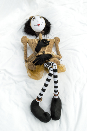 Creepy steampunk rag doll lying on back with raised knees. Viewed from above. Lifesize doll on a grungy white background. Part of a series of different poses. Vertical.の写真素材