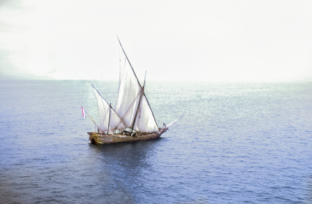 Vintage photo of a traditional dhow sailing boat in the Arabian Sea off India flying a dutch flag. Circa 1962. From a 35mm slide.の写真素材