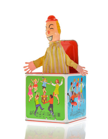 Wrexham, UK - July 02, 2018: Vintage toy clown Jack-in-the-box on a white background. Made by Hasbro in the 1970s. Pop goes the weasel song illustrated on box sides.のeditorial素材