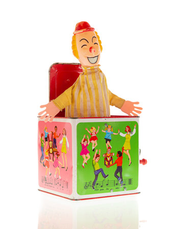 Wrexham, UK - July 02, 2018: Vintage toy clown Jack-in-the-box on a white background. Made by Hasbro in the 1970s. Pop goes the weasel song illustrated on box sides.のeditorial素材