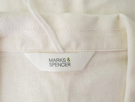 Wrexham, UK - June 07, 2018: Marks and Spencer womens clothing label on natural linen jacket collar. Close up of label.のeditorial素材