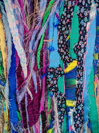 Colourful torn fabric strips, cords and wool, sewn together in a striped pattern. Textile art...