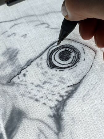 Drawing with gel pen on back lit fabric. Close up of technique to copy outline of an image onto...