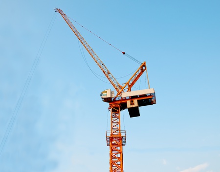 The Crane working on construction site on blue sky backgroundの写真素材