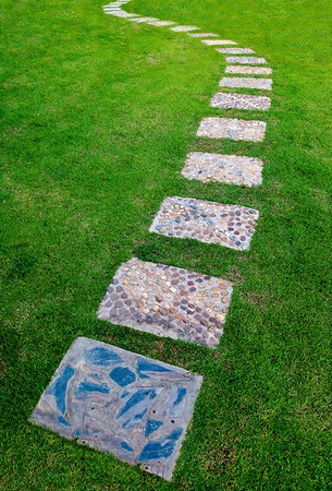 The Stone block walk path in the park with green grass backgroundの写真素材