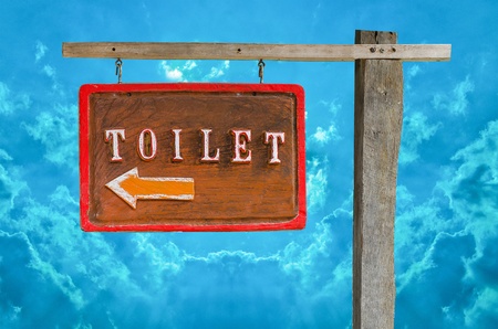 Wooden sign of toilet isolated on blue sky backgroundの写真素材